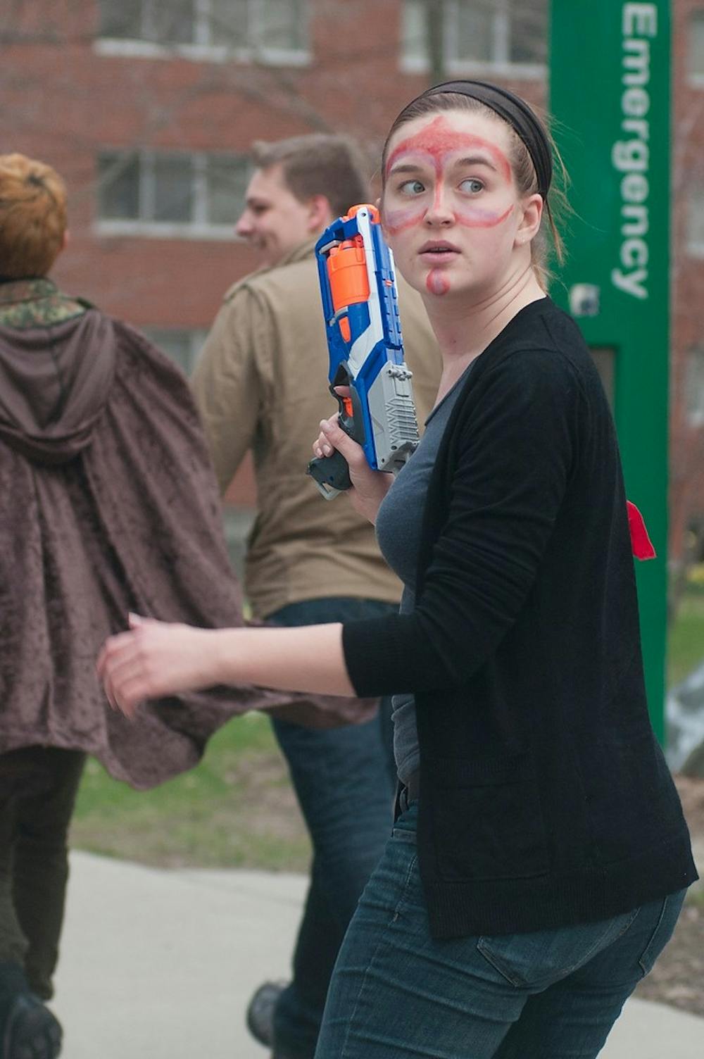 <p>Zoology junior and State News reporter Jessica Sattler watches the back of her group of Spartans April 16, 2015, during a Spartans vs. Zombies mission. The Zombies fell to the Spartans in this years game. Kennedy Thatch/The State News</p>