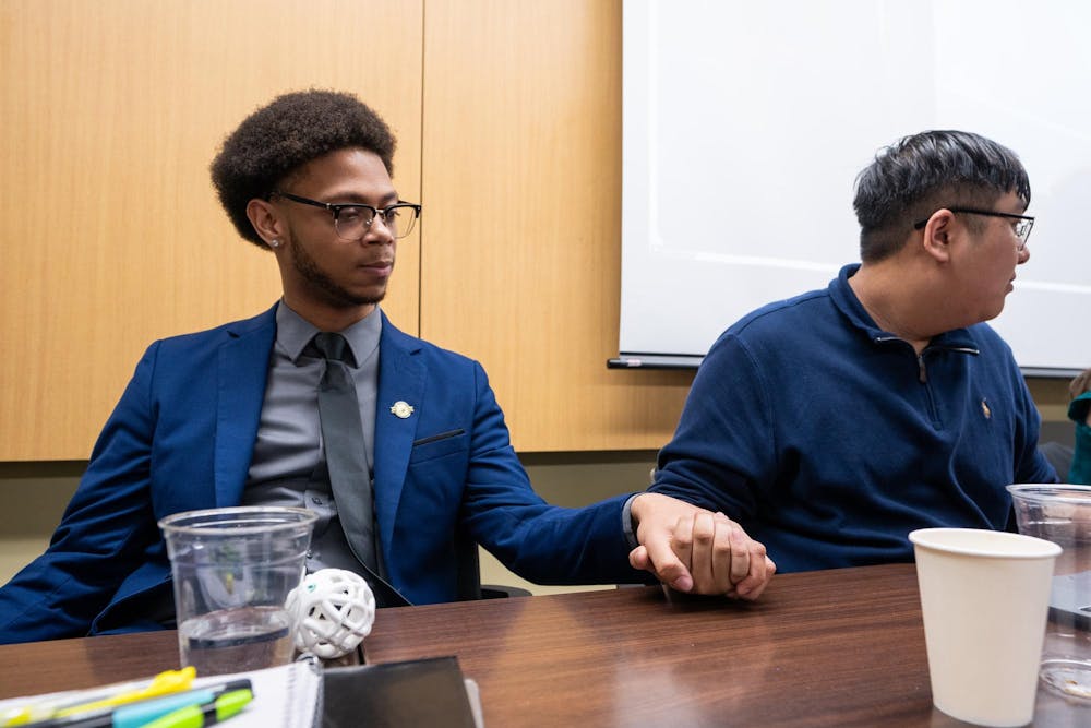 ASMSU Vice President for Governmental Affairs, Deonte Sparks (left) and ASMSU Vice President for Academic Affairs, Tony Pham (right), hold hands in hopes of Sparks winning his race for ASMSU President in the Student Affairs & Services building in East Lansing, MI on April 14, 2026.