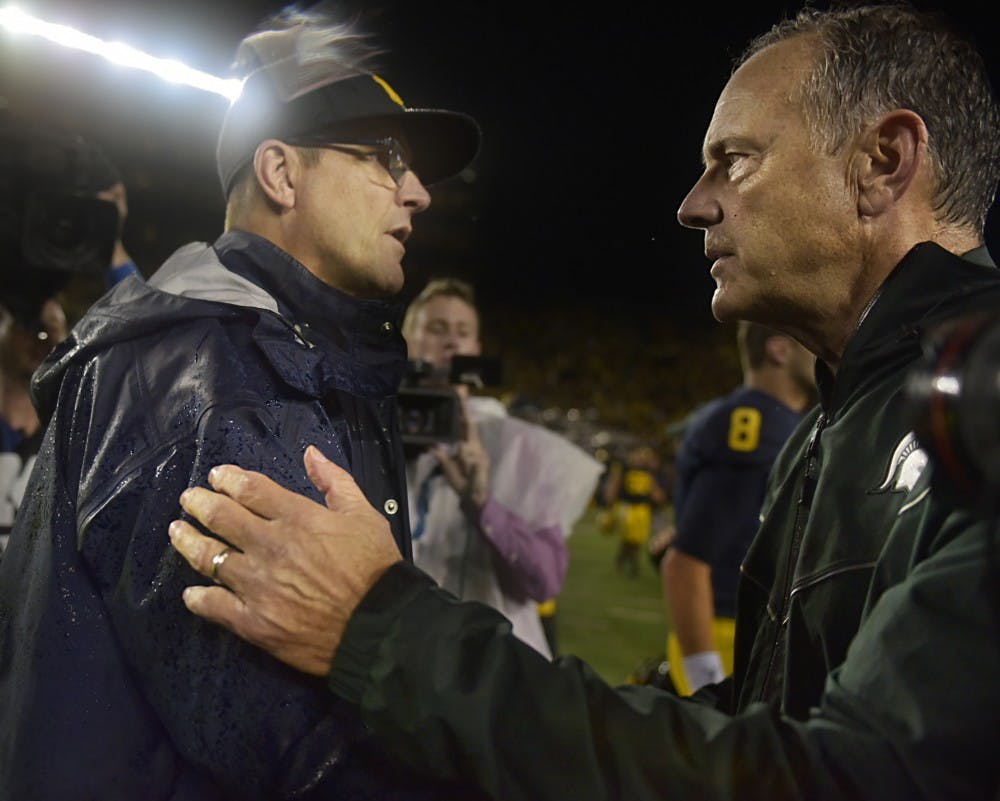 Michigan Head Coach Jim Harbaugh, left, and Head Coach Mark Dantonio shake hands after the game against Michigan on Oct. 7, 2017 at Michigan Stadium. The Spartans defeated the Wolverines, 14-10. 