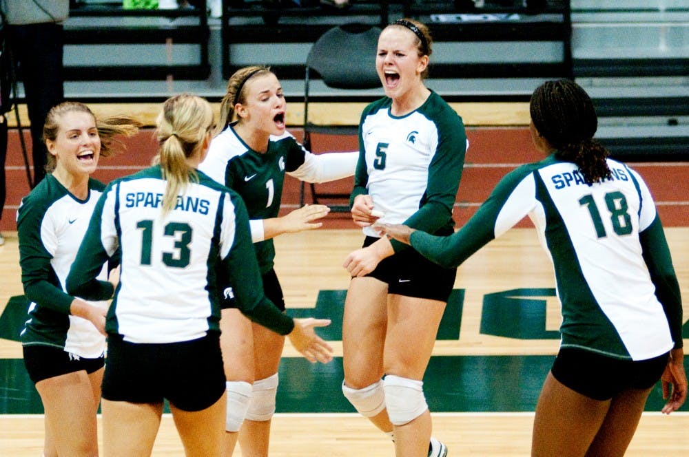 Senior outside hitter Jenilee Rathje celebrates with her teammates after Michigan State scored a point against Ball State. The Spartans defeated Ball State, 3-0, on Friday night on their way to winning the Spartan Invitation this past weekend at Jenison Fieldhouse. Josh Radtke/The State News