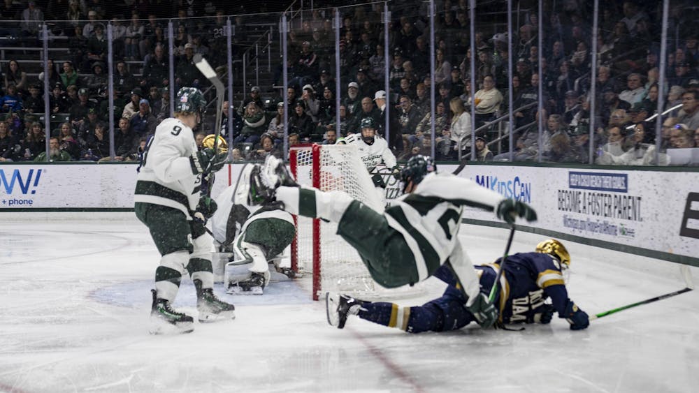 <p>MSU junior forward Daniel Russell (20) falls over Notre Dame senior forward Justin Janicke (8) at Munn Ice Arena on Nov. 15, 2024. Michigan State took the win 8-3.</p>