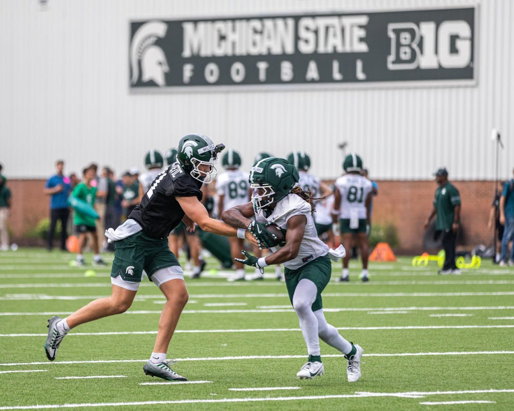 <p>Michigan State QB, Alessio Miliojevic (11), hands the ball to running back Kenneth Williams (32) at the MSU Duffy Daugherty practice fields in East Lansing, Mich., on Aug. 6, 2026.</p>