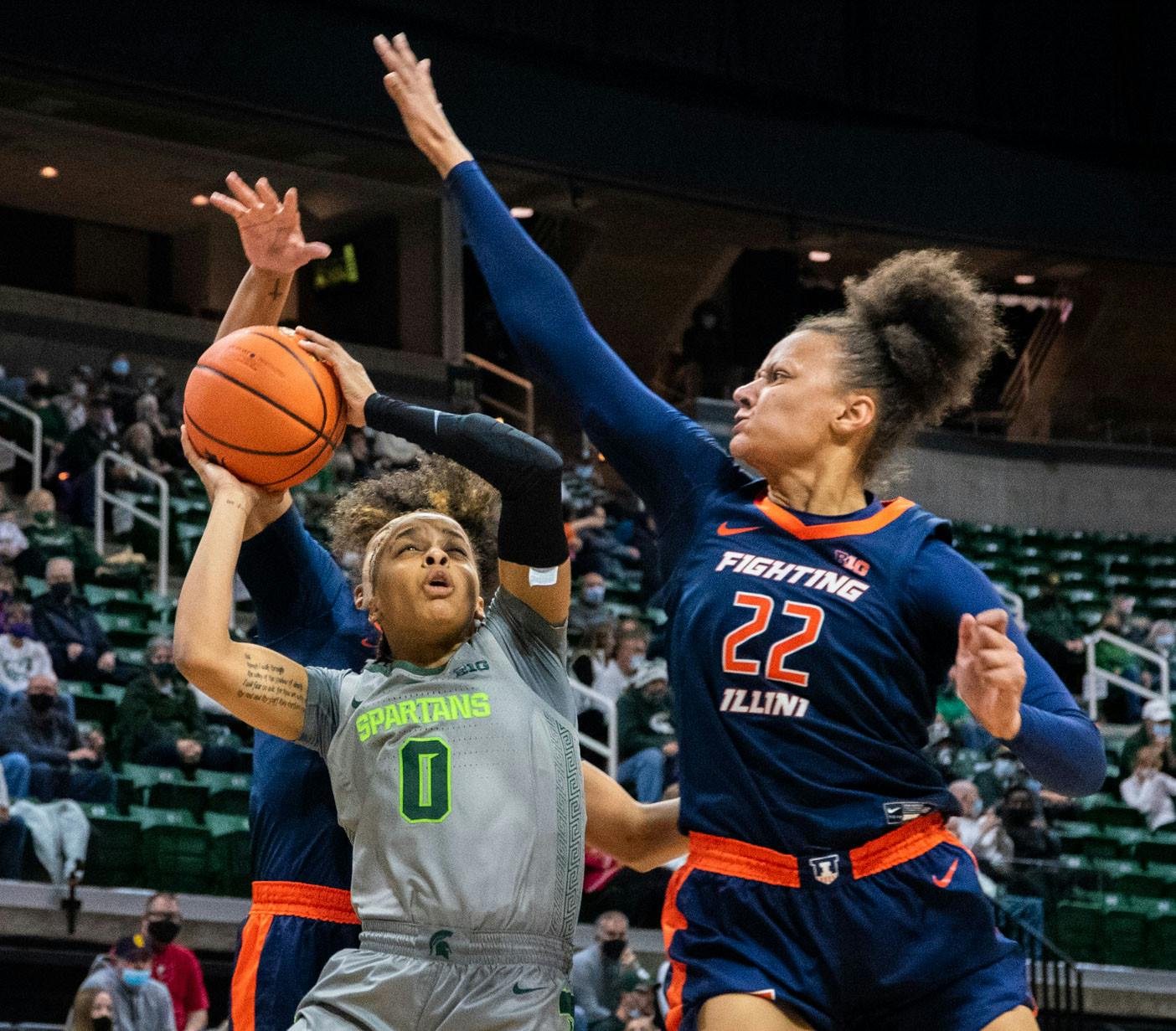 <p>Freshman guard Deedee Hagemann (0) avoids outstretched arms to score a basket in the first quarter. The Spartans beat the Fighting Illini, 75-60, in their Big Ten opener on Dec. 9, 2021. </p>