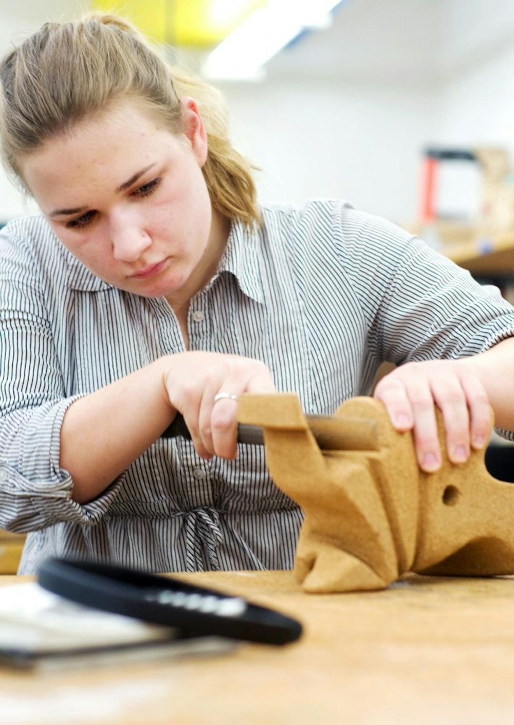 	<p>Art education freshman Emily Roussin works on a cork sculpture in her 3-D form class. “It started out as just an abstract form, and now I am seeing an elephant so I am just going to keep going with that,” Roussin said.</p>