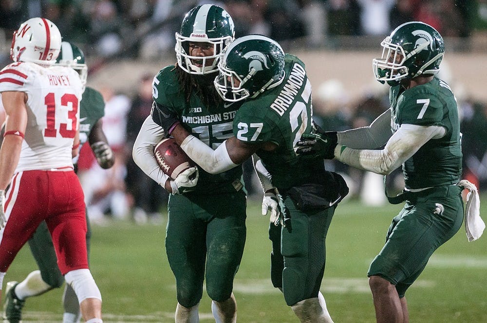 <p>Then-junior cornerback Trae Waynes, 15, celebrates his game deciding interception with junior safety Kurtis Drummond, 27, and sophomore safety Demetrious Cox, 7, during the game against Nebraska on Oct. 4, 2014, at Spartan Stadium. Waynes was drafted to the NFL this year. Raymond Williams/The State News</p>