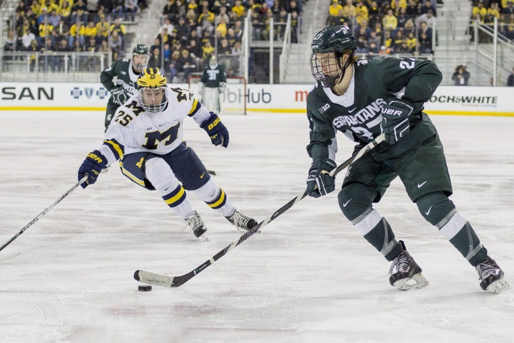 Sophomore forward Mason Appleton (27) takes the puck up the rink as Michigan forward Max Shuart (25) tries to take possession of the puck during the third period of the men?s hockey game against the University of Michigan on Feb. 11, 2017 at Yost Ice Arena in Ann Arbor. The Spartans defeated the Wolverines, 4-1. 