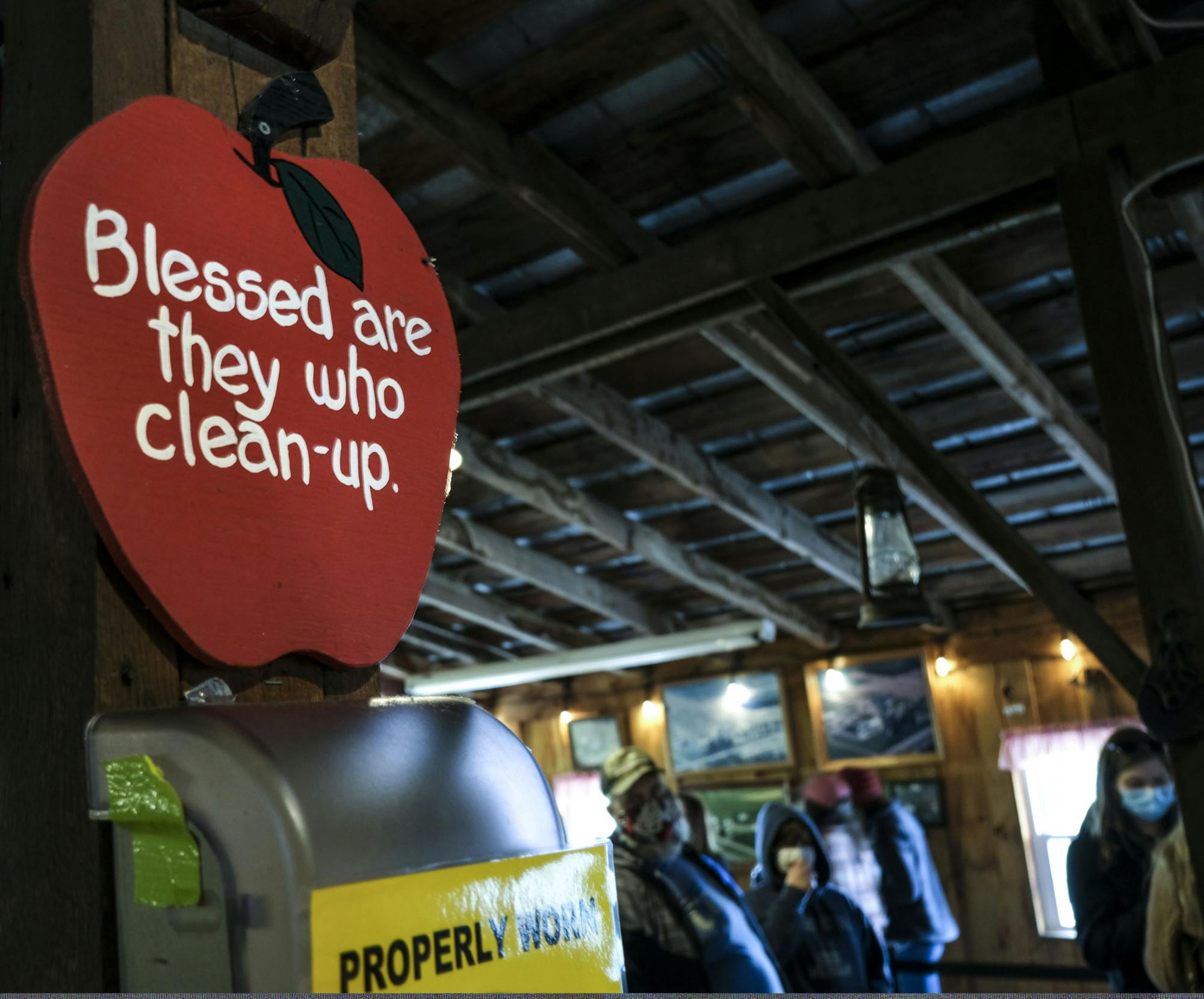 A sign shaped like an apple reads, Blessed are they who clean-up.