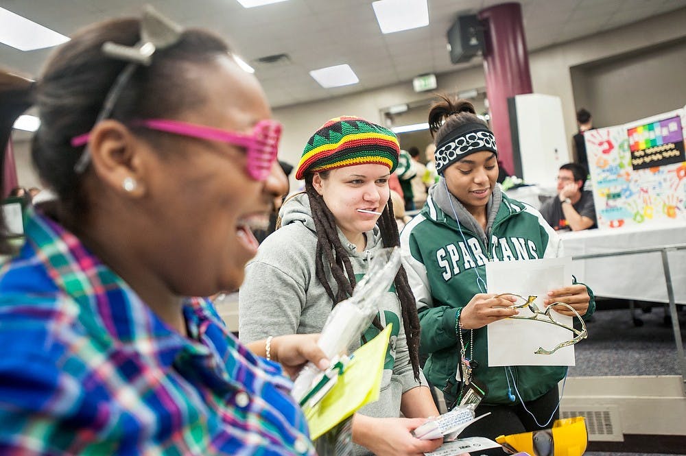 	<p>From left, psychology freshman Janel Lynn, studio art freeman Meg Piavis, athletic training freshman Ksenija Taylor try out props at McDonel Hall Kiva during the opening celebration of the River Trail Engagement Center, MOndat, Jan. 14, 2013. Justin Wan/The State News</p>