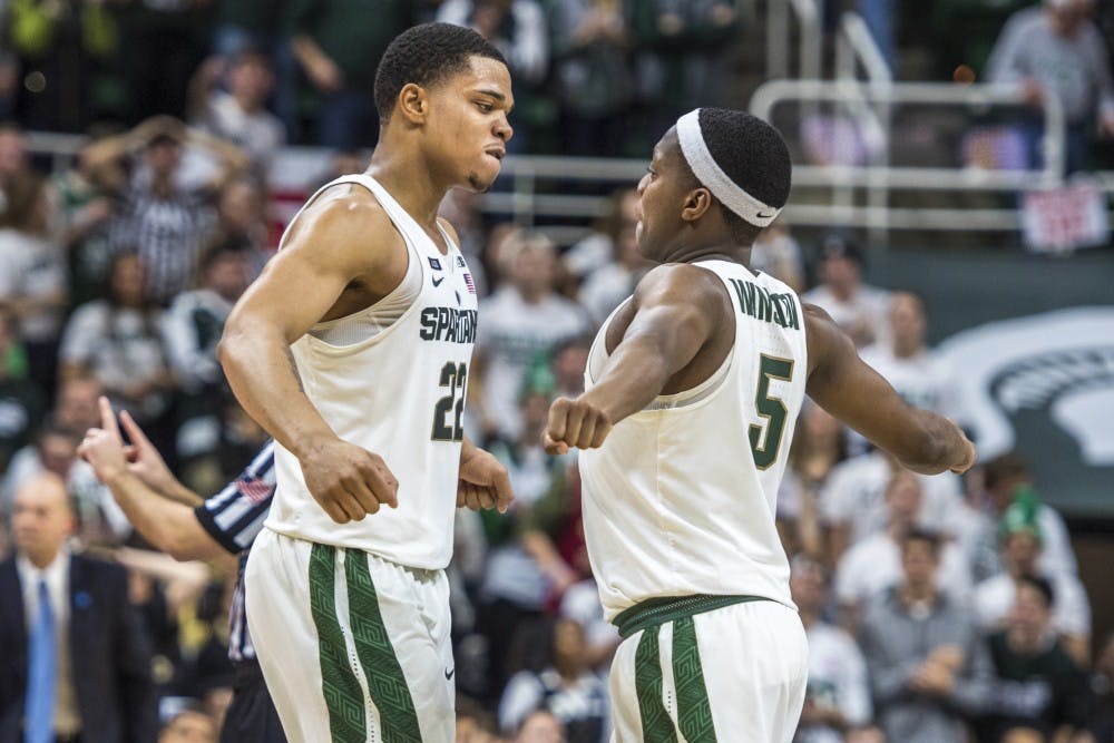 Sophomore guard Miles Bridges (22) and sophomore guard Cassius Winston (5) go in for a chest bump during the second half of the men's basketball game against Purdue on Feb. 10, 2018 at Breslin Center. The Spartans defeated the Boilermakers, 68-65. (Nic Antaya | The State News)