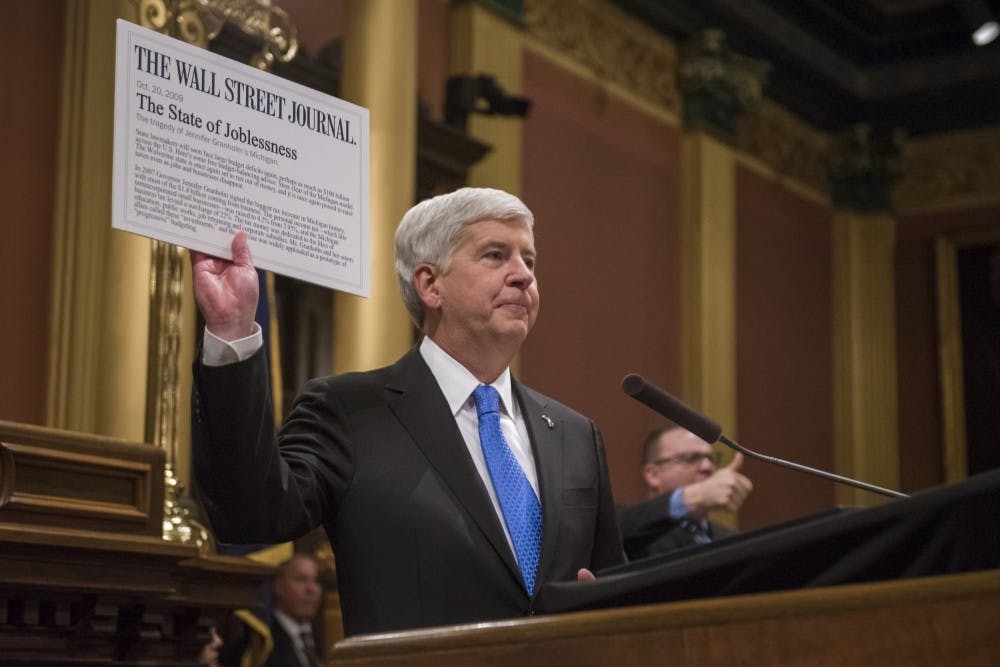 Gov. Rick Snyder holds up an article from The Wall Street Journal as he addresses the audience during the State of the State Address on Jan. 23, 2018 at the Capitol in Lansing. (Nic Antaya | The State News)