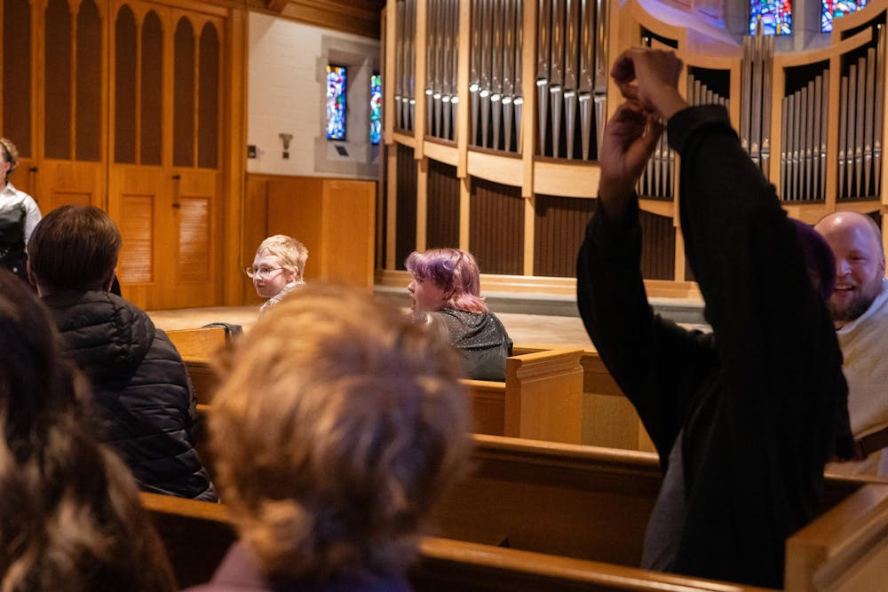 <p>The crowd roars as the artists perform their set at the Alumni Memorial Chapel on April 13. A supporter is shown making the number eight with his hands, indicating the performer had a good performance. </p>