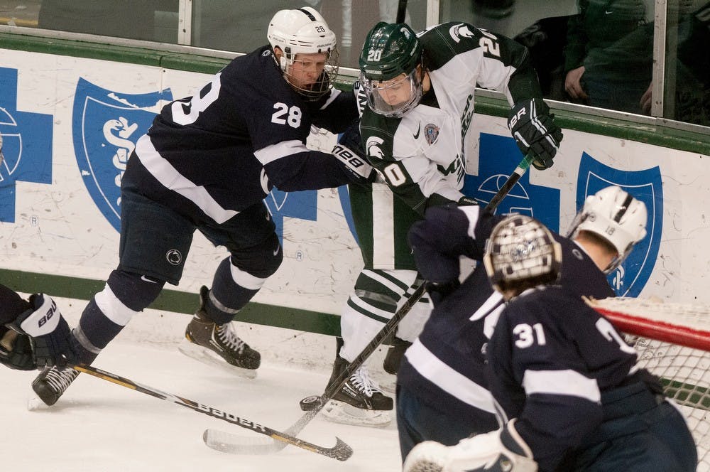 	<p>Freshman forward Michael Ferrantino and Penn State junior Taylor Holstrom fight for possession of the puck Jan. 26, 2013, at Munn Ice Arena. The Spartans lost, 3-2. Julia Nagy/The State News</p>