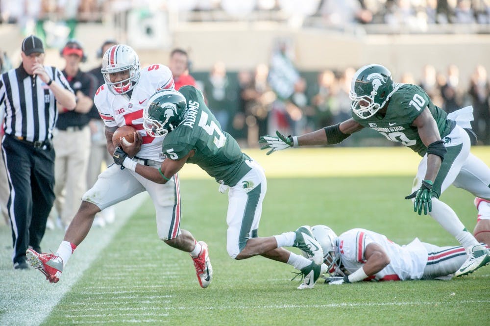 	<p>Senior cornerback Johnny Adams tackles Ohio State quarterback Braxton Miller. The Buckeyes defeated the Spartans, 17-16, on Saturday, Sept. 29, 2012 at Spartan Stadium. Justin Wan/The State News</p>