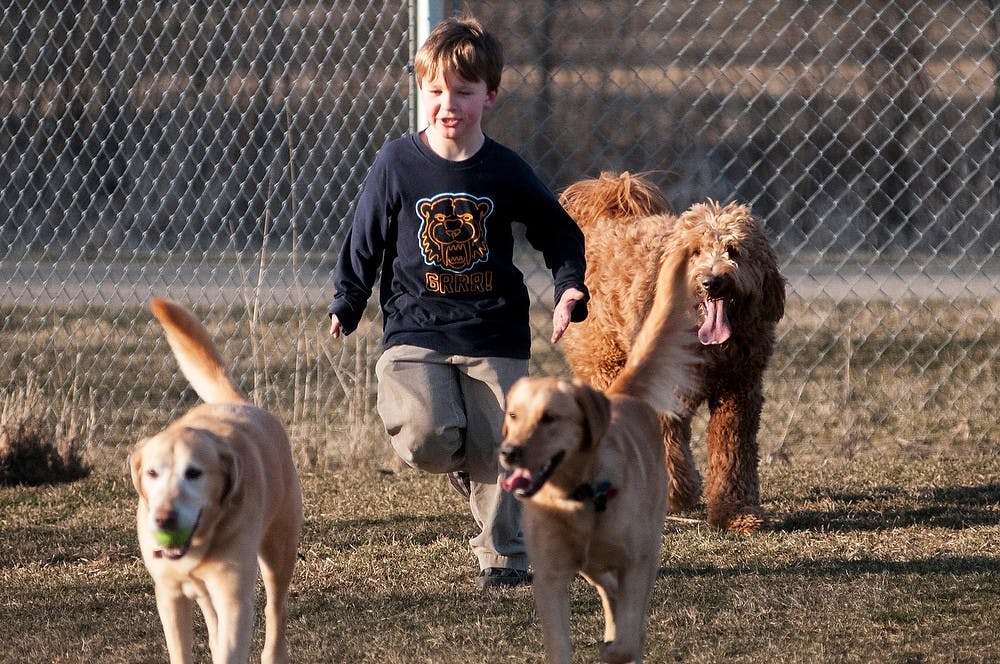 	<p>Okemos resident Branden McClurkin,7, runs with dogs April 3, 2013, at Northern Tail Dog Park, 6400 Abbot Road. McClurkin also played fetch with any dog that came up to him with a frisbee or ball.</p>