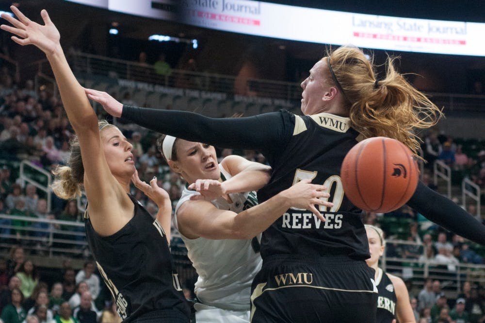 <p>Junior guard Tori Jankoska passes the ball between Western Michigan forward Jessica Jessing, left, and Western Michigan forward Teagan Reeves and during the first half of the game against Western Michigan on Nov. 15, 2015 at Breslin Center. The Spartans defeated the Broncos , 78-40.</p>