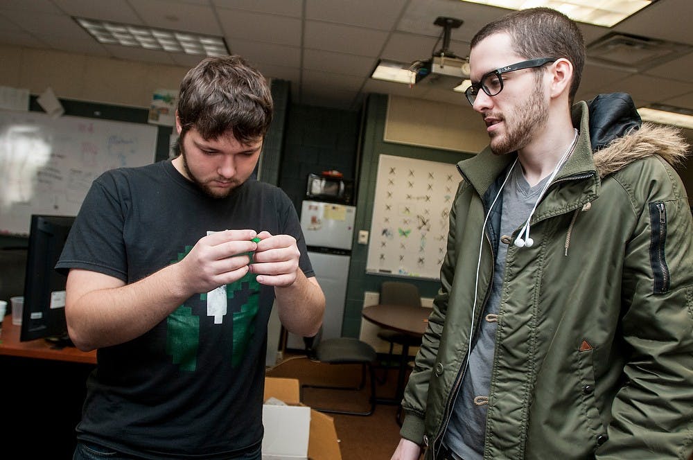 	<p>Spartasoft president and computer science senior David Ward, left, and digital media arts and technology senior Evan Cox inspect a 3D printed model on Dec. 2, 2013, in the <span class="caps">GEL</span> Lab located in the Communication Arts and Sciences Building. Spartasoft is a game design club where members learn and work on creating digital games. Khoa Nguyen/The State News</p>