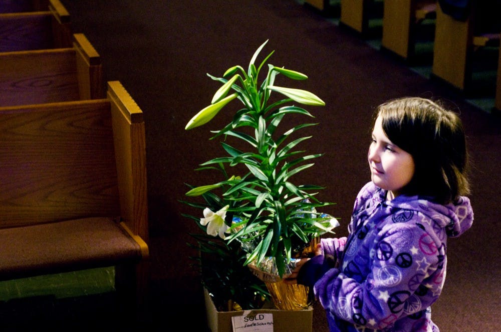 	<p>Lansing resident Mia Mayville, 7, carries a lily to the alter Saturday morning at the Peoples Church of East Lansing, 200 W. Grand River Ave. The Peoples Church of East Lansing ordered a large amount of lilies to decorate their place of worship for Easter.</p>