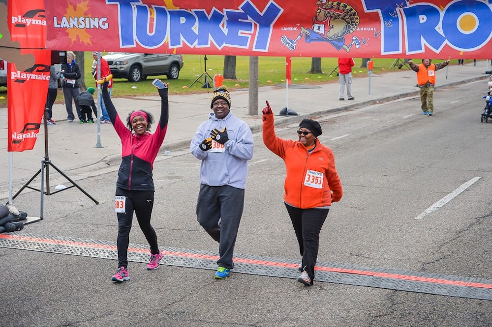 <p>Participants cross the finish line at the Lansing Turkey Trot 5K. Photo courtesy of the Michigan Running Foundation.</p>