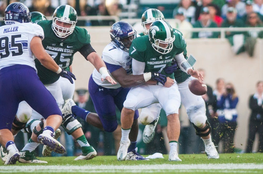 Senior quarterback Tyler O'Connor (7) is sacked for a loss of 5 yards and fumbles the football during the third quarter in the game against Northwestern on Oct. 15, 2016 at Spartan Stadium. The ball was recovered by Northwestern defensive lineman Joe Gaziano (97). The Spartans were defeated by the Wildcats, 54-40.
