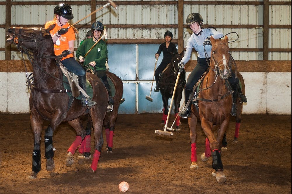 <p>Graphic design sophomore Katelynn Humble, left, and political theory and constitutional democracy junior Meghan Mitchum play polo March 30, 2014, during an MSU Polo Club practice at Sandalwood Ranch in Williamston. This was the MSU Polo Club's last week of practice. </p>