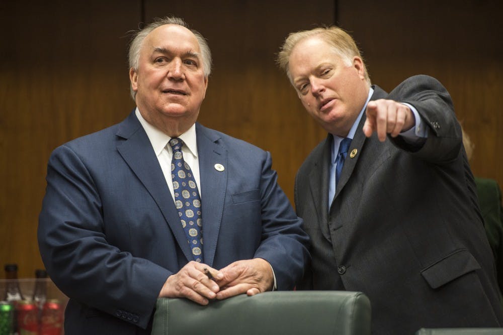 Interim President John Engler, left, and interim athletic director Bill Beekman interact before the Board of Trustees meeting on Feb. 16, 2018 at the Hannah Administration Building. (Nic Antaya | The State News)