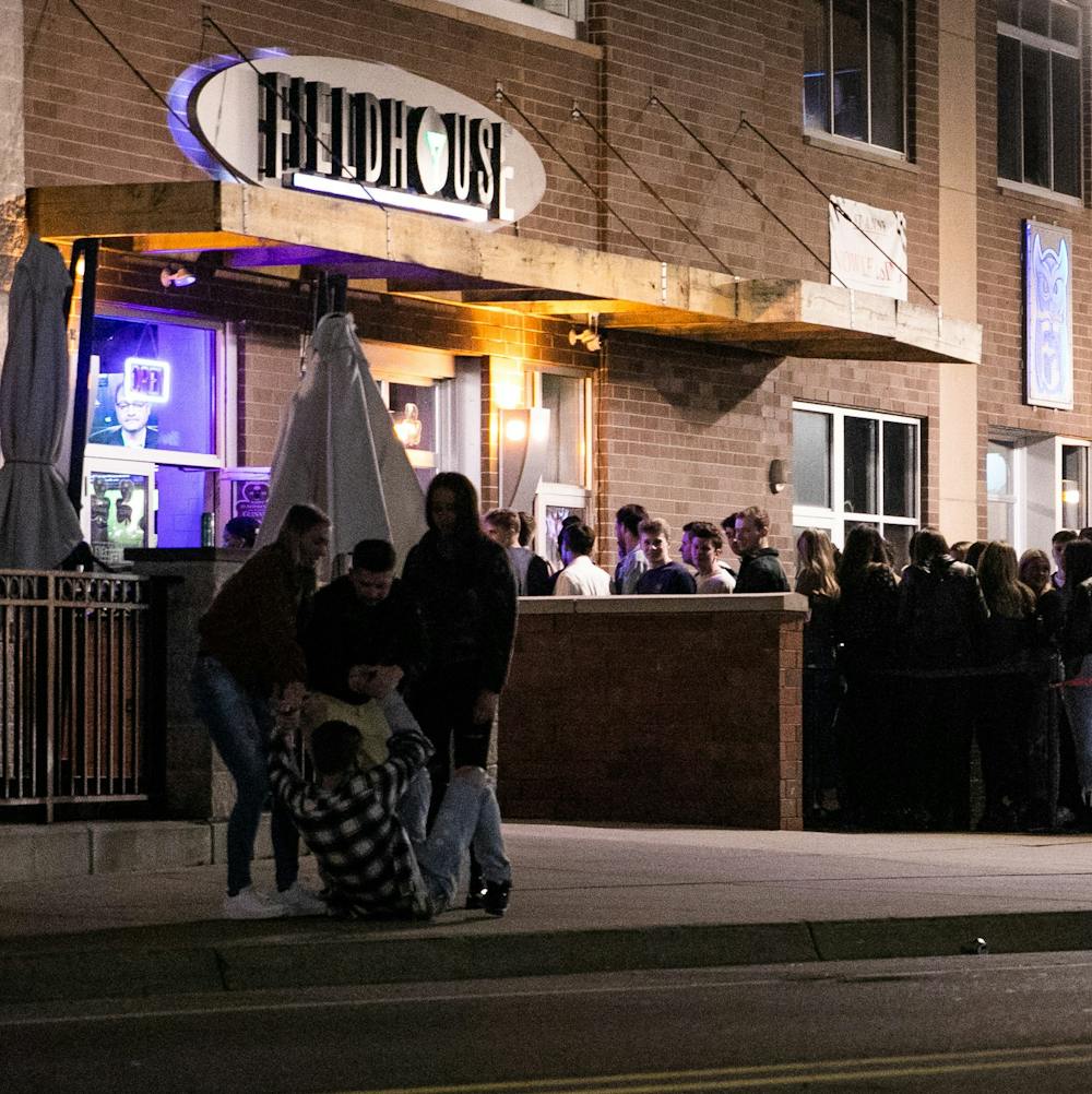 People help pick up a friend who had fallen over outside the bars after MSU cancelled classes due to coronavirus March 11, 2020.