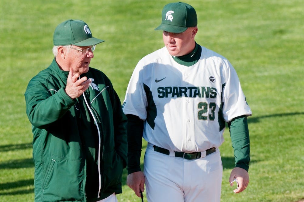 Former head coach Jake Boss Sr. talks with head coach Jake Boss Jr. at the conclusion of the game against Western Michigan on Tuesday afternoon at McLane Baseball Stadium at Old College Field. Justin Wan/The State News