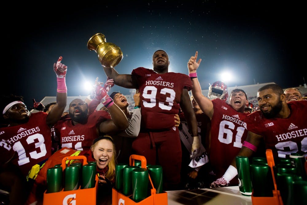 Indiana defensive lineman Ralph Green (93) holds onto The Old Brass Spittoon and celebrates with teammates after winning the MSU game against Indiana on Oct. 1, 2016 at Memorial Stadium in Bloomington, Ind. The Spartans were defeated by the Hoosiers in overtime, 24-21.