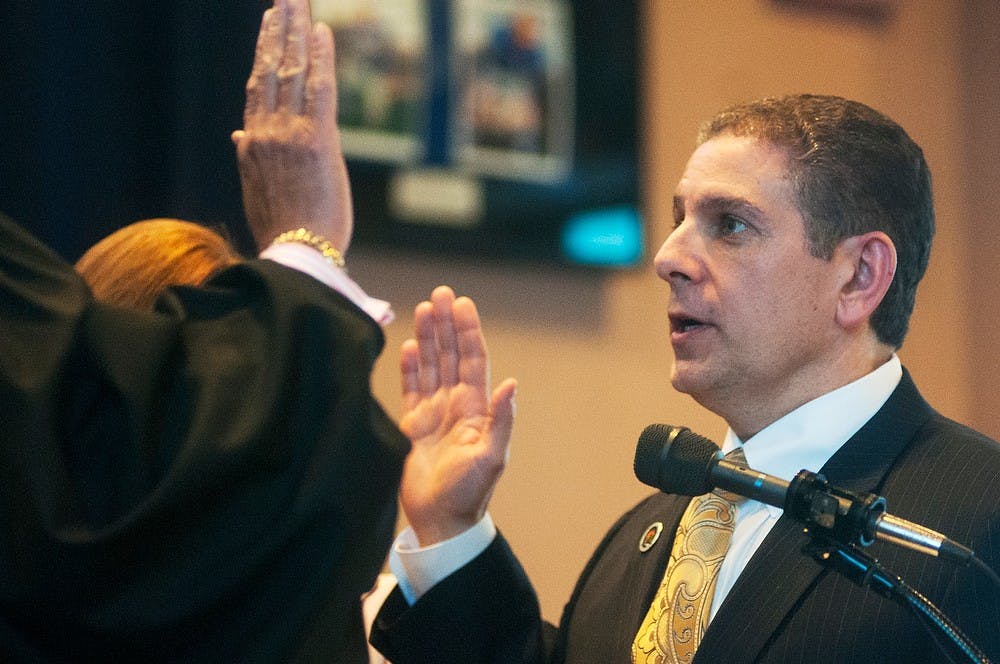 	<p>Lansing mayor Virg Bernero is sworn in by 54-A District Court judge Hugh Clarke during the Inaugural Ceremony on Jan. 13, 2014, at the Lansing Center. Bernero and other members of Lansing&#8217;s city council took the Oath of Office following the 2013 election season in November. Danyelle Morrow/The State News</p>