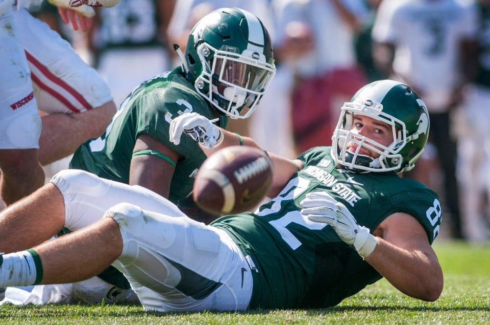 Sophomore running back LJ Scott (3) and senior tight end Josiah Price (82) stare at the football shortly after Scott fumbled the ball during the game against Wisconsin on Sept. 24, 2016 at Spartan Stadium. The fumble was recovered by Wisconsin linebacker Leo Musso and was ran 66 yards for a touchdown. The Spartans were defeated by the Badgers, 30-6.