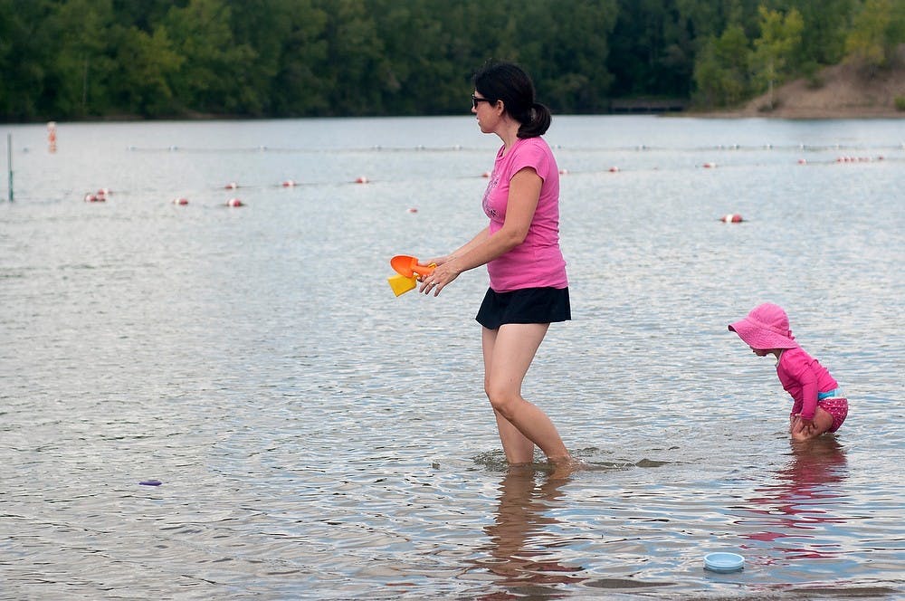 <p>Okemos, Mich., resident Sally Deroo and her daughter Maddie Deroo, 1, enjoy the lake at Hawk Island Park on Aug. 27, 2014. Raymond Williams/The State News</p>