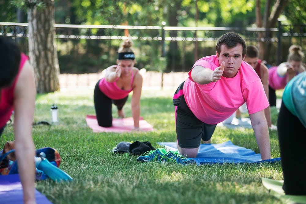 <p>Musicology graduate student Trevor Nelson practices yoga July 26, 2014, at the Eli and Edythe Broad Art Museum on campus. Yoga instructor Tara Scott has been teaching yoga for eight years. Scott teaches yoga as a way to build community and connection with others.  Corey Damocles/The State News </p>