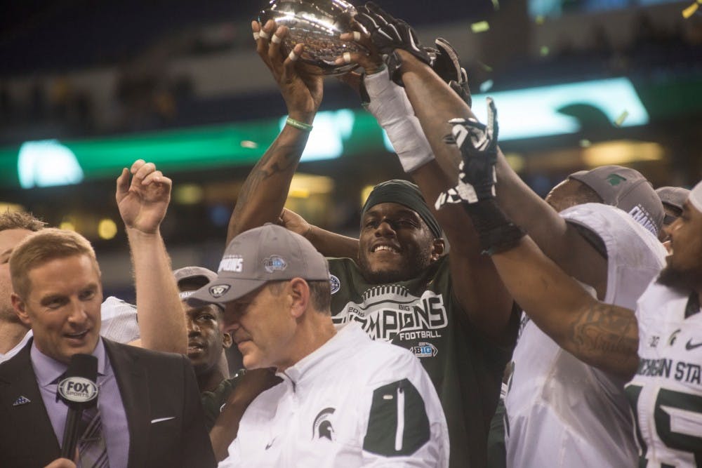 Senior defensive end Shilique Calhoun holds up the Big Ten championship trophy on Dec. 5, 2015 at the Big Ten championship game against Iowa at Lucas Oil Stadium in Indianapolis. The Spartans defeated the Hawkeyes 16-13. 