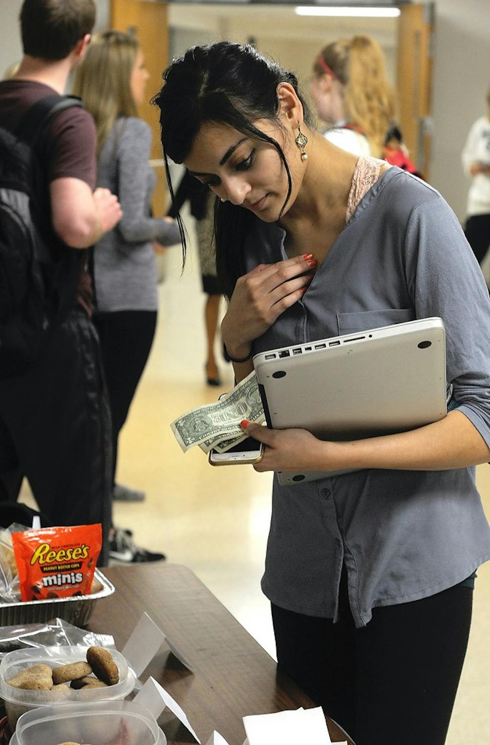 <p>First year osteopathic medicine major Naila Abdullah looks to purchase a bake good April 28, 2015 at the bake sale for Detroit Rescue Mission Ministries. Students from MSU were raising money through donations in order to volunteer in Detroit this coming May. Alice Kole/The State News</p>