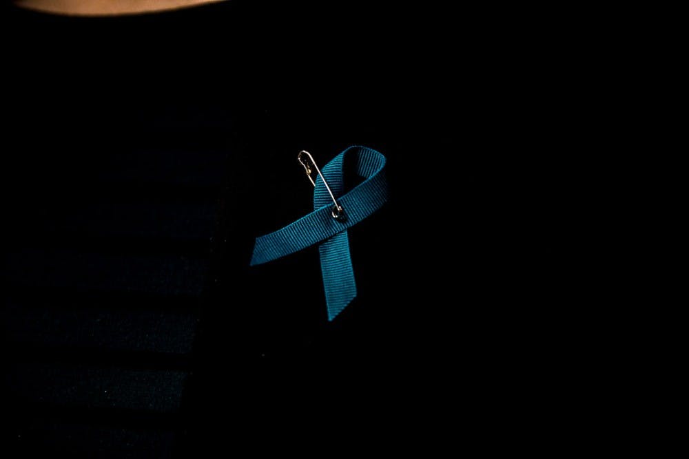 <p>A woman wears a teal ribbon during a Board of Trustees meeting on Jan. 13, 2019 at the Hannah Administration Building. </p>