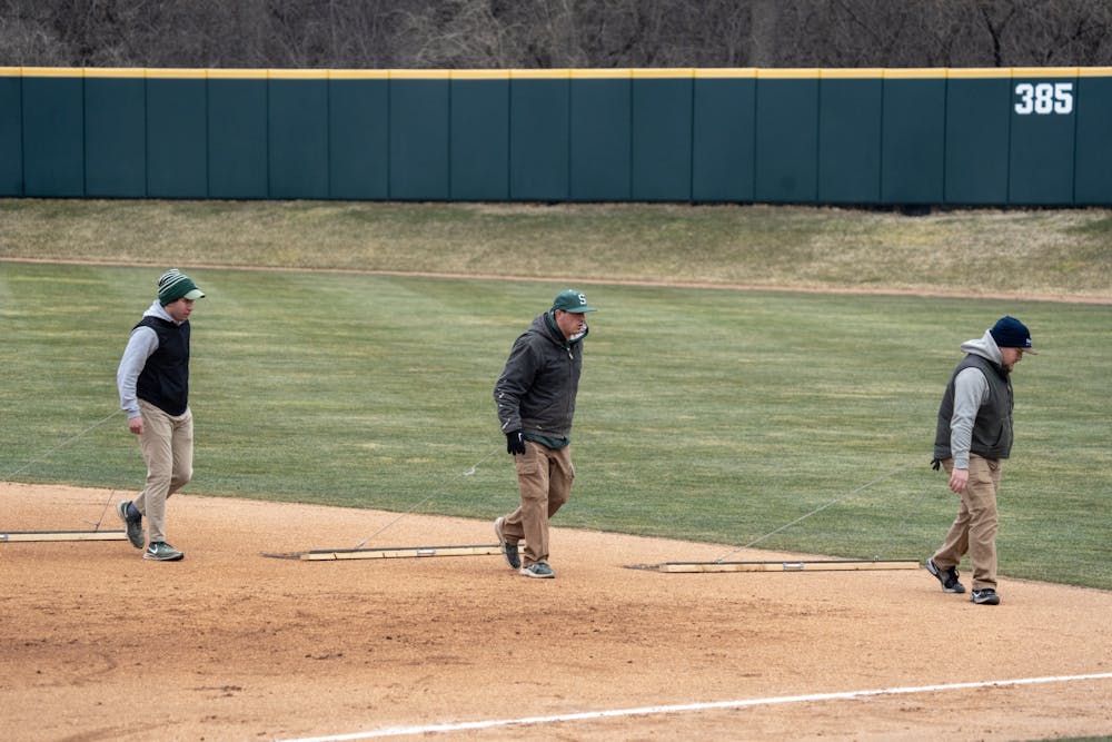 <p>The Michigan State Grounds crew drags the field during the Spartan's Baseball home opener against Western Michigan.</p>