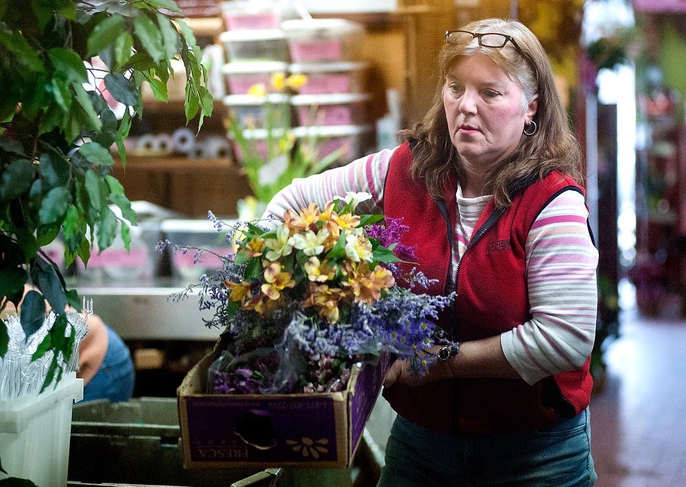 	<p>Ruth Leyrer, owner of Bancroft Flowers, carries flowers at the back of the store of Bancroft Flowers, 1417 E. Michigan Ave., in Lansing, Thursday, Feb. 7, 2013. </p>