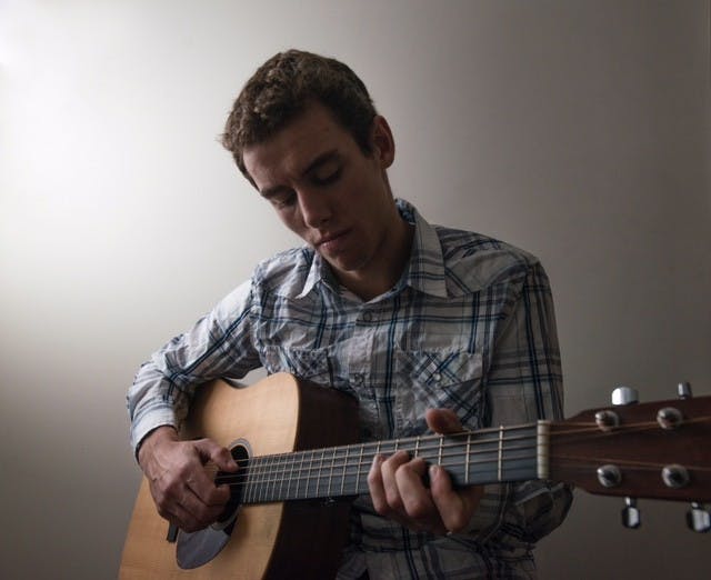 Business-preference sophomore Murphy Nye poses for a portrait on Dec. 7, 2016 at his apartment in East Lansing. Nye taught himself how to play guitar and has used music as a form a therapy to help cope with his depression. Nye said that "Stop This Train" by John Mayer saved his life one day during his freshman year when he was actively feeling suicidal. 