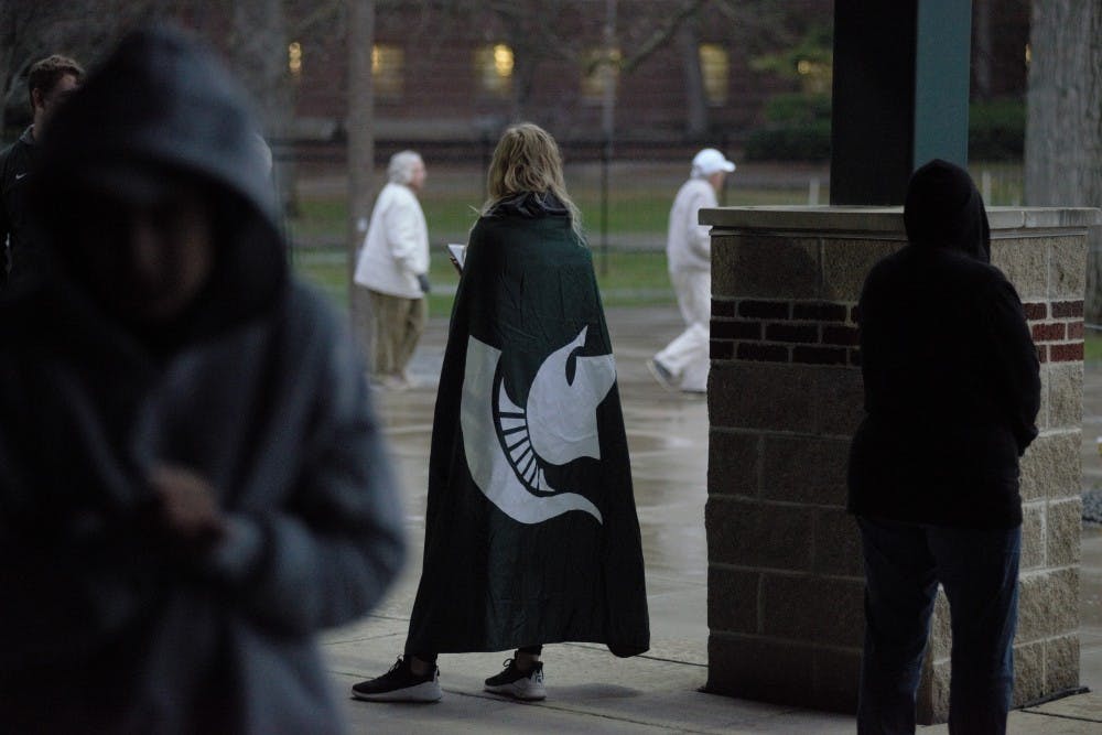 <p>A spartan fan attempts to wait out the rain during the game with Eastern Michigan at McLane Baseball Stadium on April 17, 2019.  MSU defeated EMU 5-3.</p>
