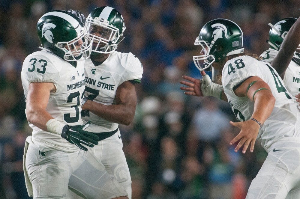 <p>Teammates congratulate junior linebacker Jon Reschke (33) during the game against Notre Dame on Sept. 17, 2016 at Notre Dame Stadium in South Bend, Ind. The Spartans defeated the Fighting Irish, 36-28. (State News File Photo)</p>