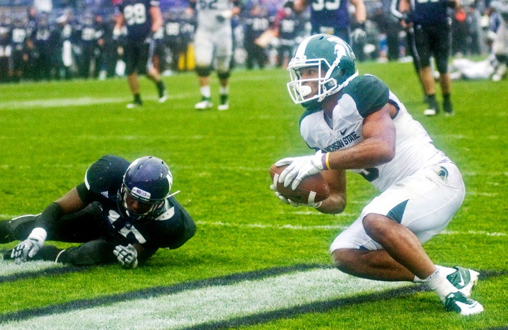 Senior wide receiver B.J. Cunningham gets up from the ground after scoring one of his two touchdowns. The Spartans defeated the Wildcats, 31-17, Saturday afternoon at Ryan Field, in Evanston, Ill. Justin Wan/The State News