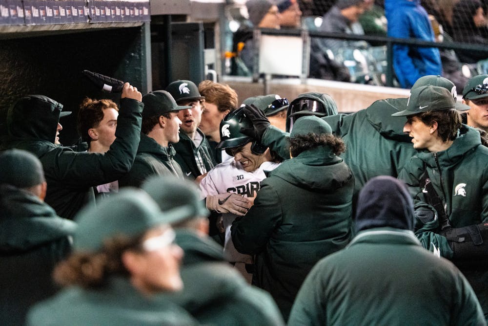 <p>MSU celebrates a run in the dugout. The Spartans played Notre Dame at Comerica Park on April 26, 2022.</p>
