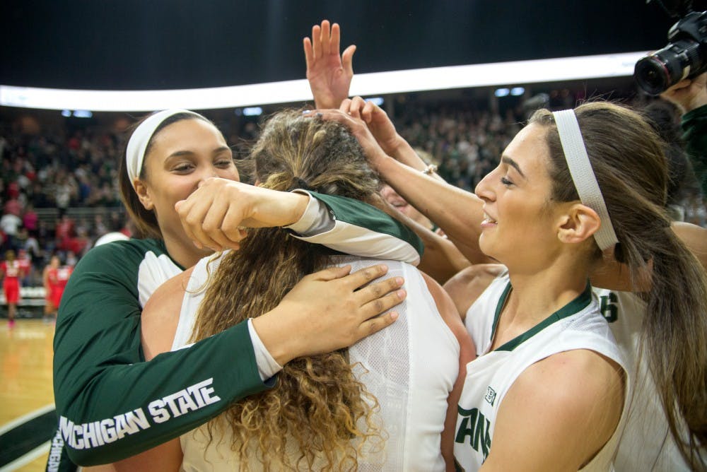 From left to right, sophomore forward Kennedy Johnson, graduate student center Jasmine Hines and senior guard Cara Miller celebrate their victory after the game against Ohio State on Feb. 27, 2016 at Breslin Center. The Spartans defeated the Buckeyes, 107-105 in triple overtime.