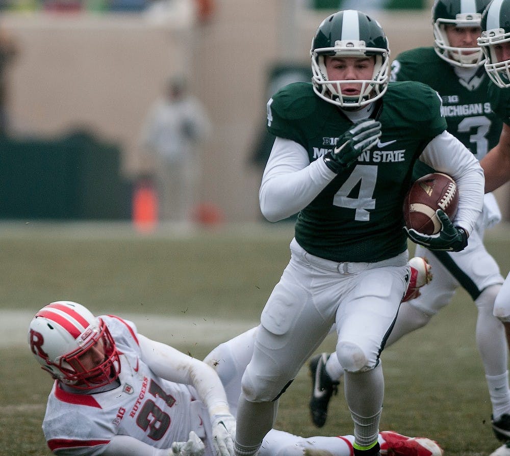 <p>Sophomore kicker Michael Geiger maneuvers past Rutgers defensive back Anthony Cioffi and rushes towards the end zone Nov. 22, 2014, during the game at Spartan Stadium. The Spartans defeated the Scarlet Knights, 45-3. Raymond Williams/The State News</p>