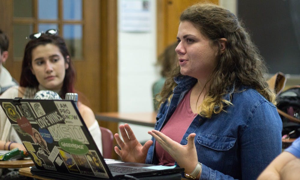 Psychology senior Emily Torossian, left, listens while comparitive cultures and politics senior Karen Troxell, right, talks about carbon neutrality during the Greenpeace meeting on Oct. 18, 2017 at Berkey Hall. The Greenpeace chapter at MSU will soon launch a campaign about carbon neutrality.
