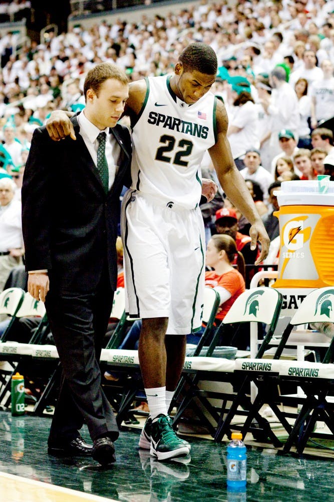 Freshman guard Branden Dawson is helped off of the floor after tearing his anterior cruciate ligament Sunday, March 4 at Breslin Center. Dawson will be forced to sit out from the NCAA tournament due to the injury. Matt Hallowell/The State News