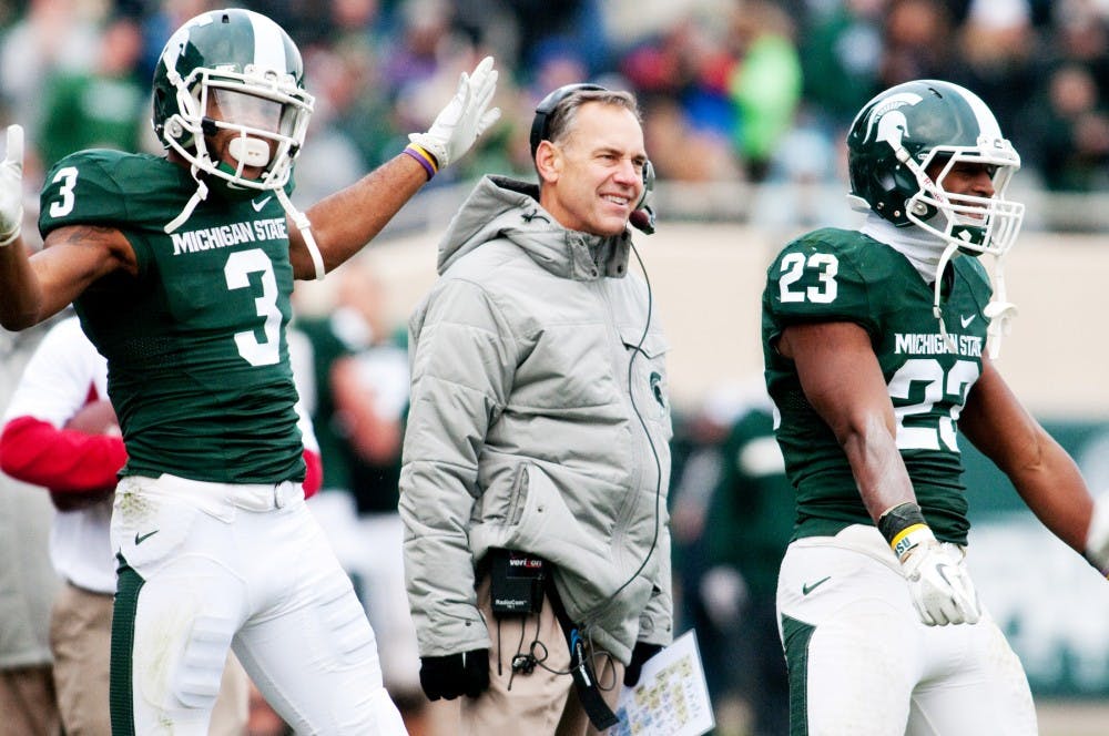 Senior wide receiver B.J. Cunningham, head coach Mark Dantonio and sophomore safety Jairus Jones react after junior cornerback Johnny Adams returned an interception for a touchdown. The Spartans defeated the Hoosiers, 55-3, on Saturday afternoon at Spartan Stadium. Josh Radtke/The State News