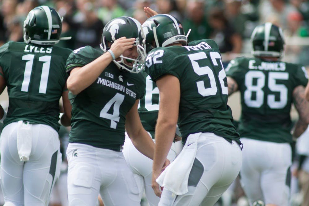 <p>Senior long snapper Taybor Pepper, 52, celebrates with junior kicker Michael Geiger after an extra point attempt during the second quarter of the game against Air Force on Sept. 19, 2015, at Spartan Stadium. The Spartans defeated the Falcons, 35-21. Alice Kole/The State News</p>