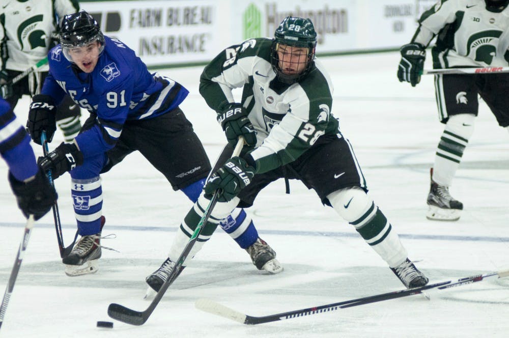 <p>Junior forward Thomas Ebbing and Western Ontario left wing Luke Karaim try to take control of the puck during the exhibition hockey game against Western Ontario on Oct. 4, 2015 at Munn Ice Arena. The Spartans defeated the Mustangs, 2-1.</p>