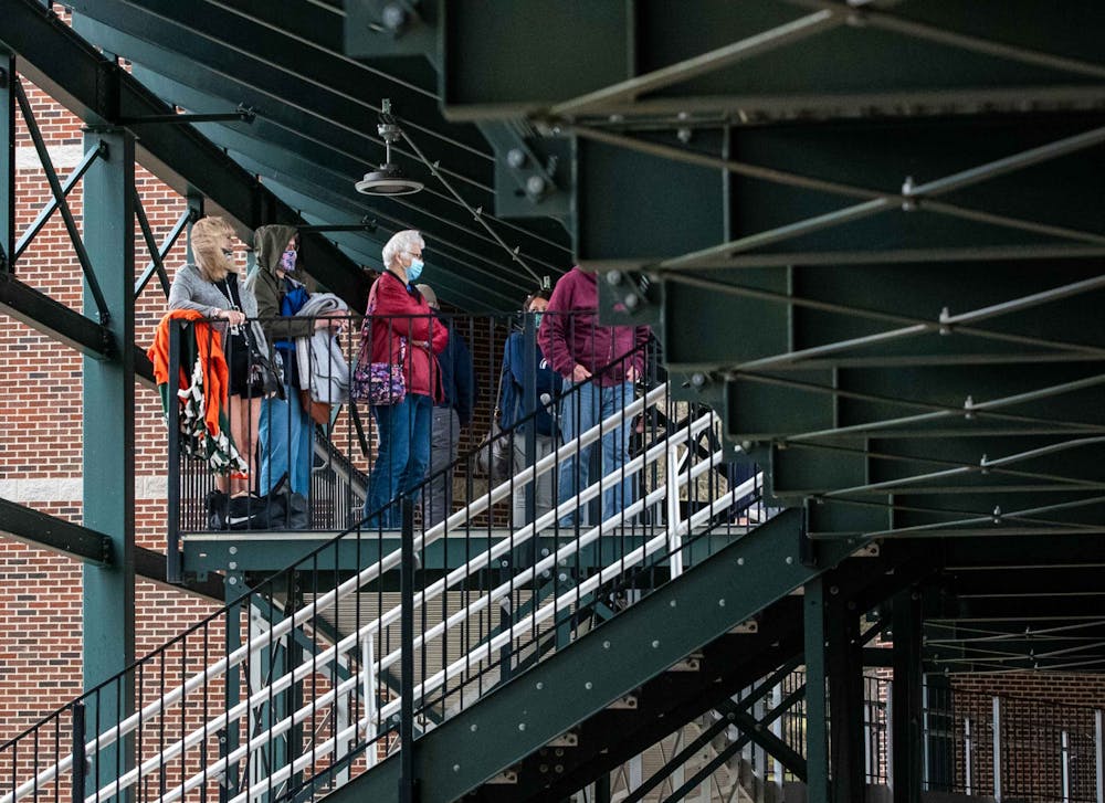 Fans huddle under the covering in the bleachers just as the rain had delayed the game. The Spartans excelled against the Nittany Lions and won 7-4 at McLane Baseball Field on April 9, 2021.